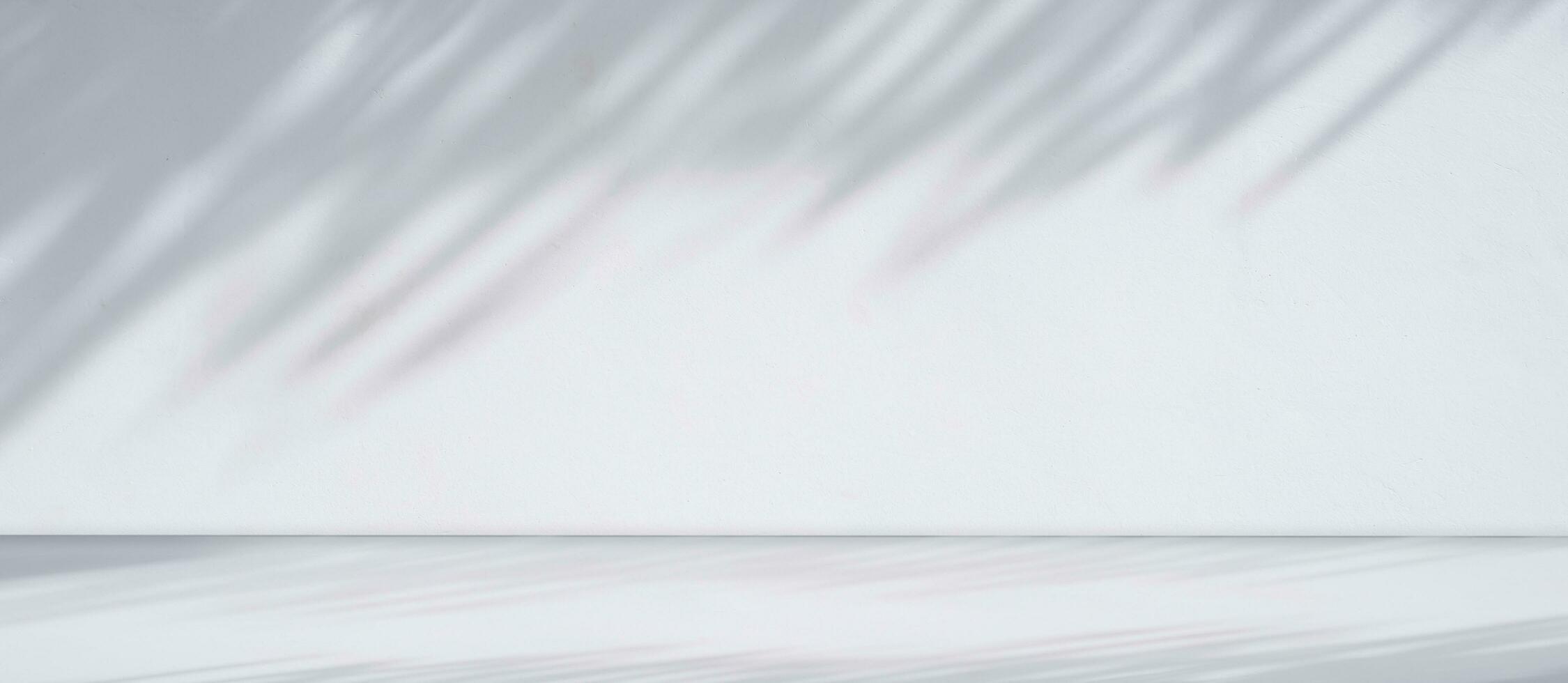 Panoramic view of empty white counter with sunlight and branch shadow on white cement wall room background, suitable for product Display Presentation photo