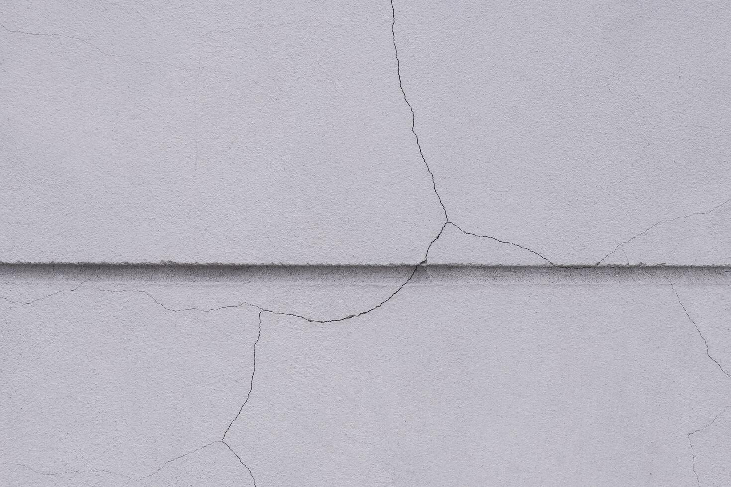 Crack line texture on surface of concrete fence wall background outside of building, close up shot with copy space photo