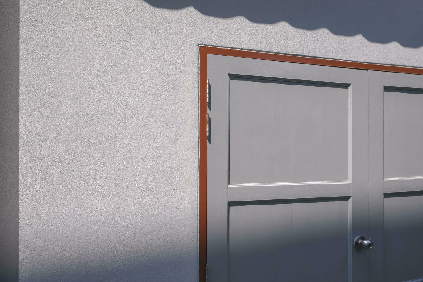 luz de sol y sombra en superficie de de madera puerta en gris cemento pared de almacén en perspectiva lado ver foto