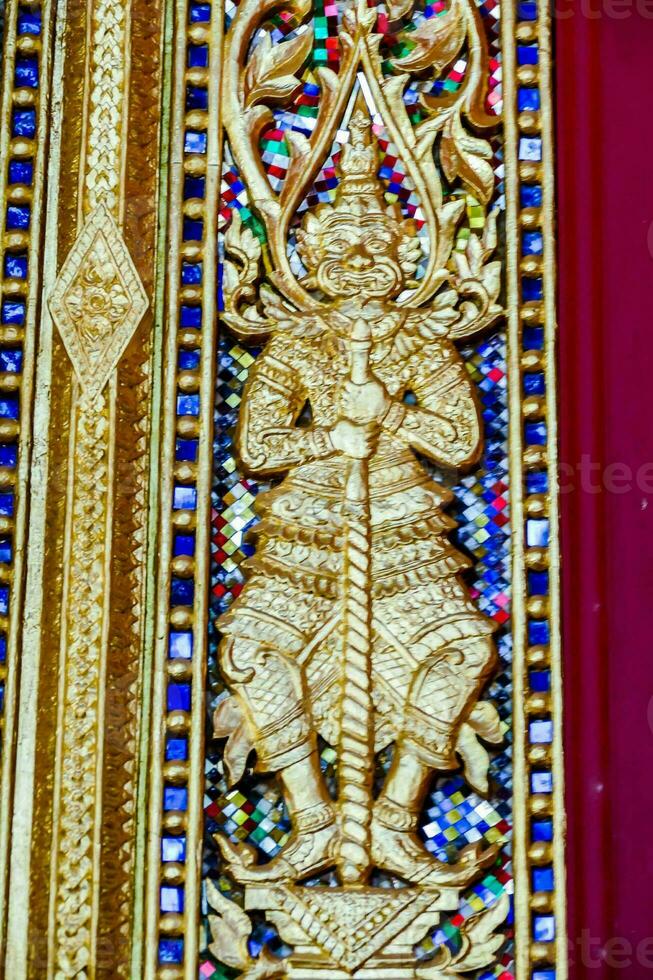 a gold and blue ornate wall decoration with a statue photo