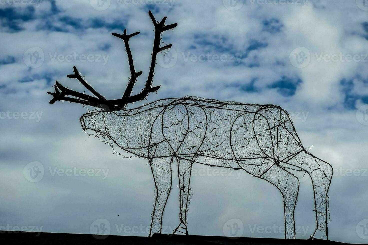 a wire sculpture of a reindeer on top of a roof photo