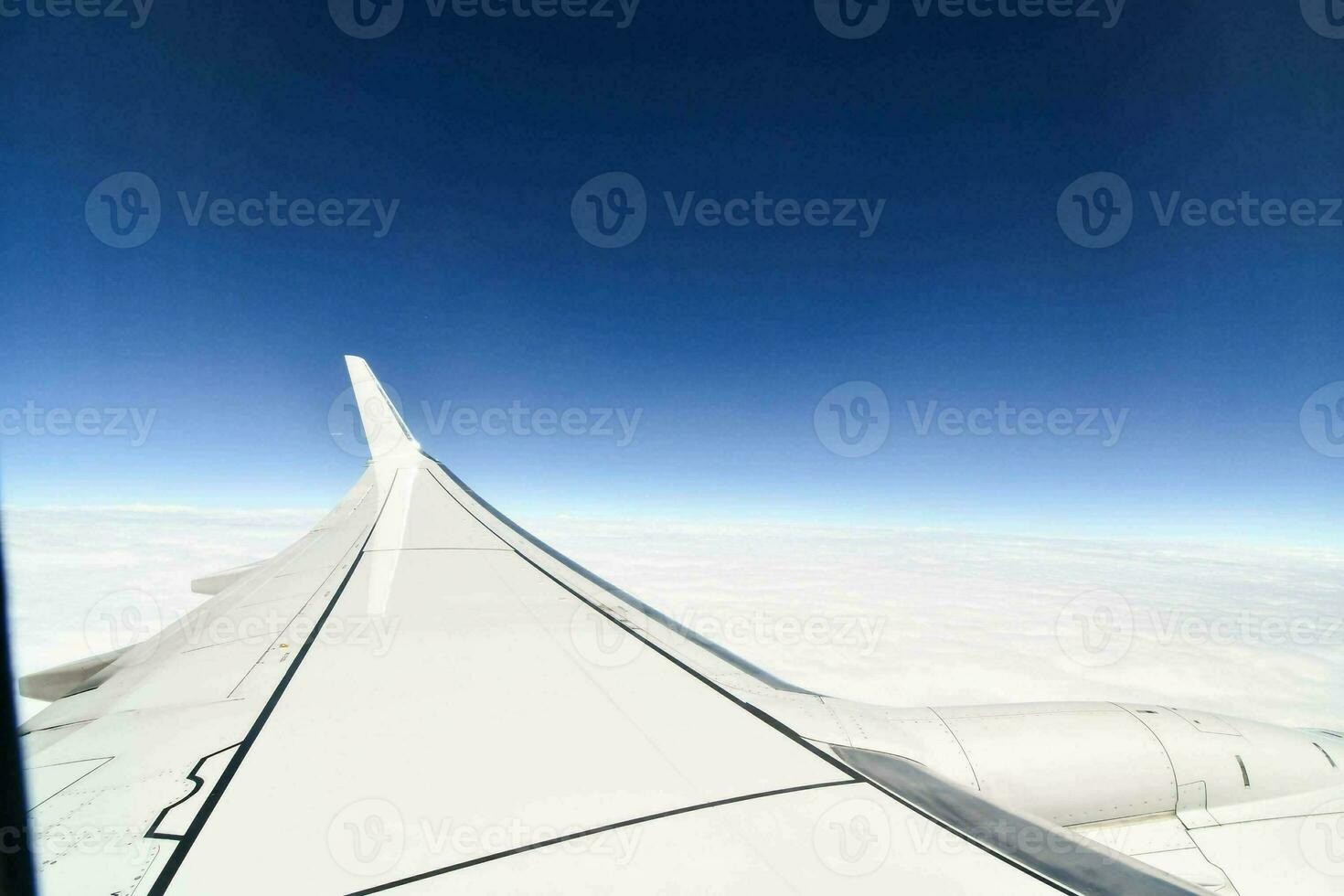 an airplane wing with a blue sky and clouds in the background photo