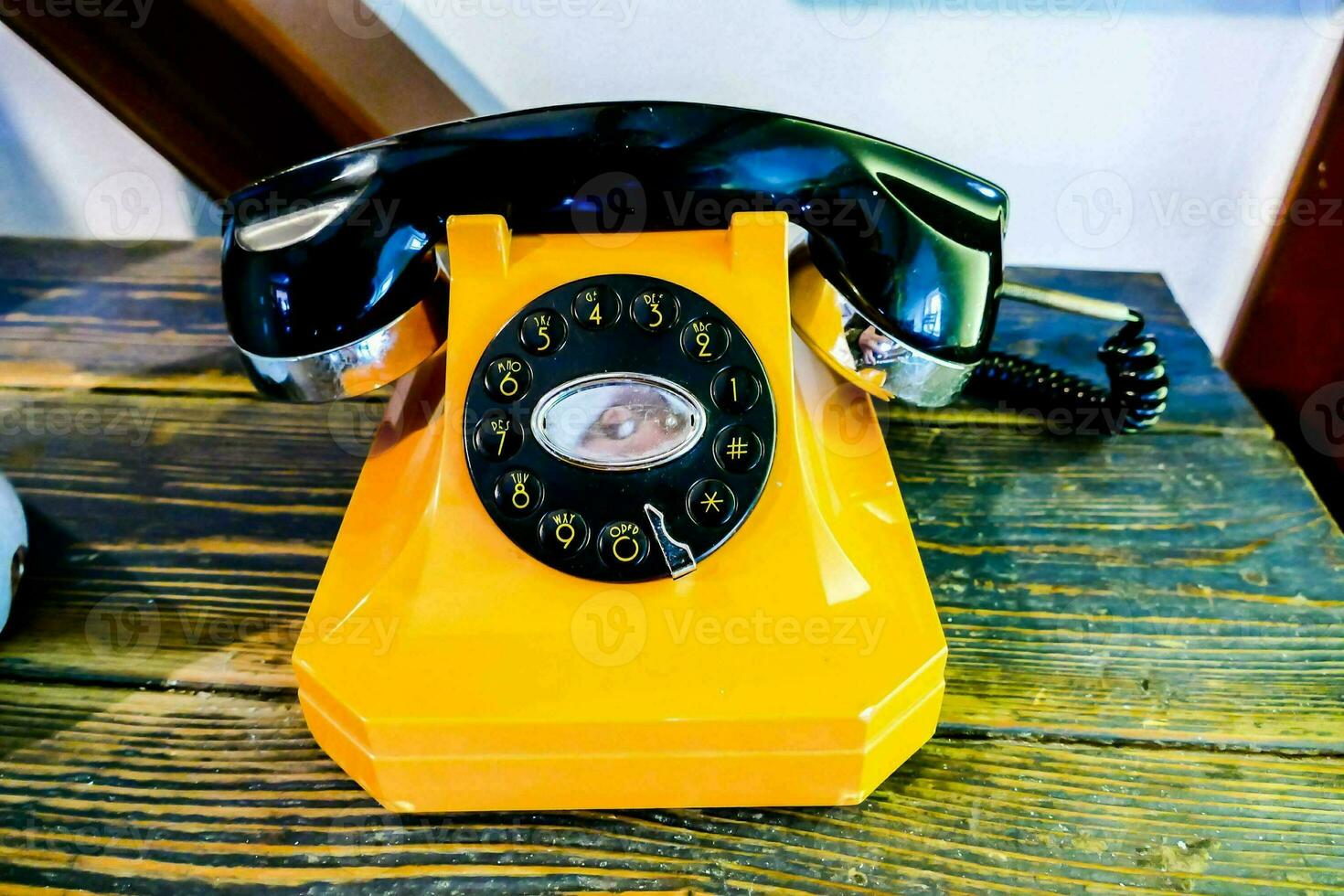 a yellow telephone on a wooden table photo
