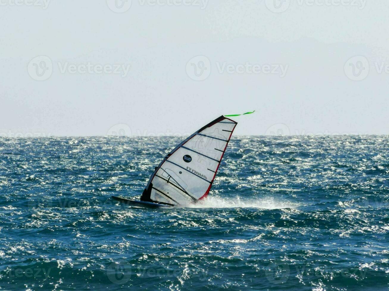 a windsurfer is sailing in the ocean photo