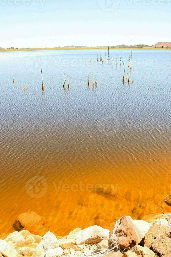 un lago con naranja agua y rocas foto