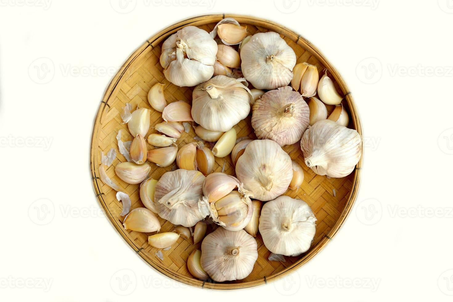 Garlic in a bamboo basket on a white background It is a medicinal plant in Thai kitchens used as an ingredient in food. It has a pungent odor and a spicy taste. It can be eaten both fresh and cooked. photo