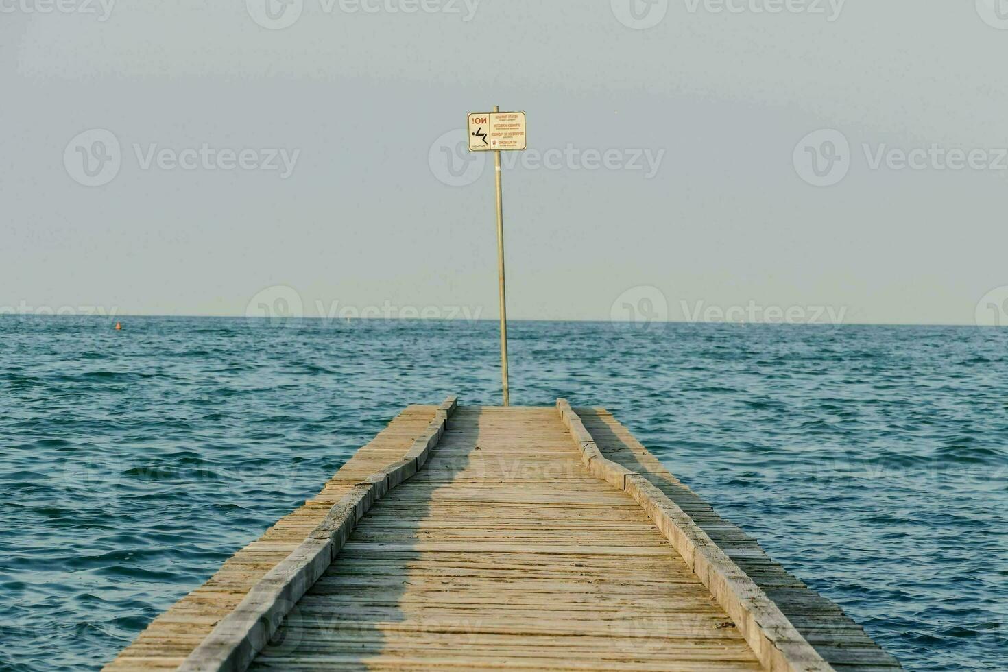 a wooden pier with a sign on it photo