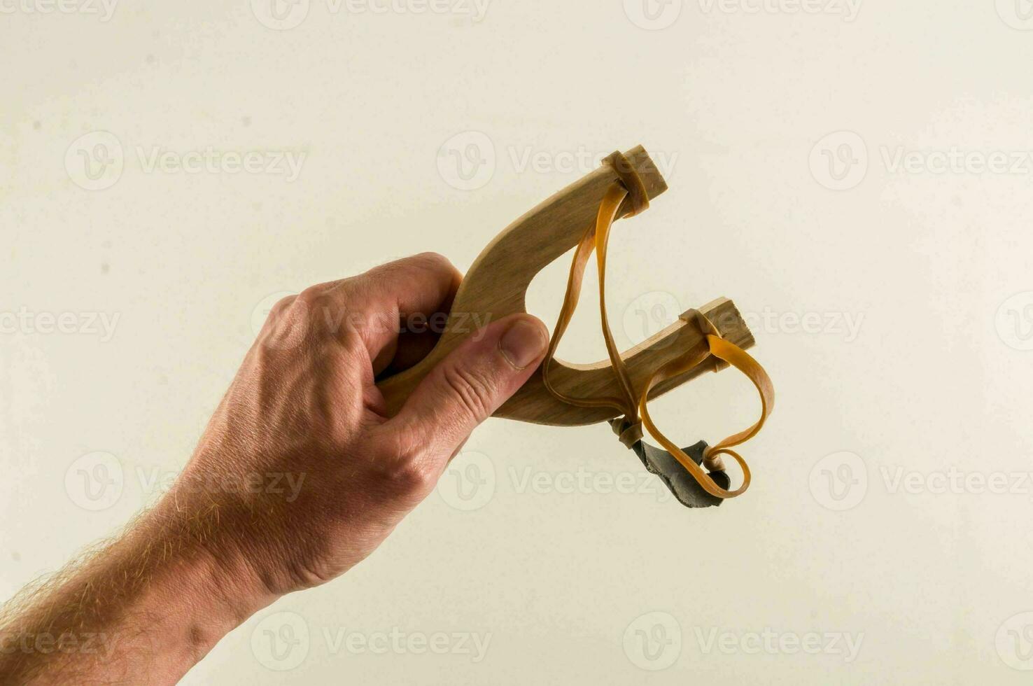 a hand holding a slingshot photo