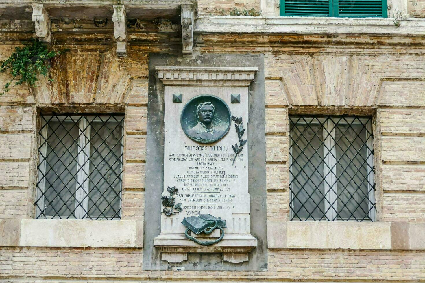 un placa en el lado de un edificio con un retrato de un hombre foto