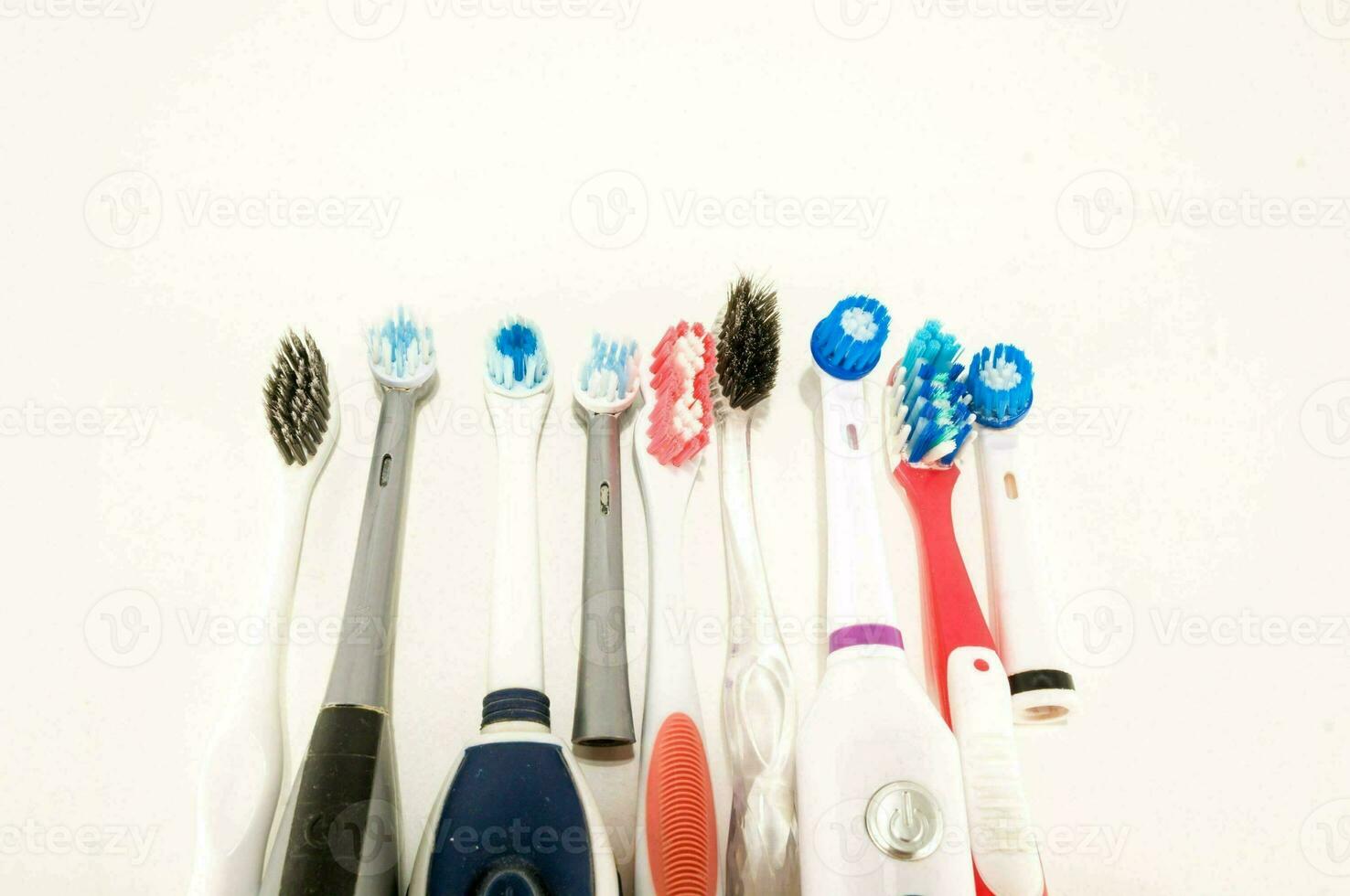 a group of different toothbrushes on a white surface photo