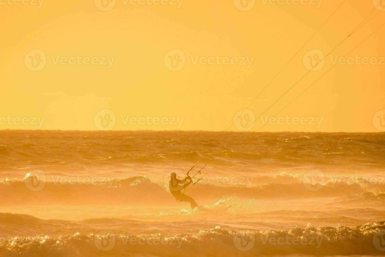 un hombre cometa embarque en el Oceano a puesta de sol foto