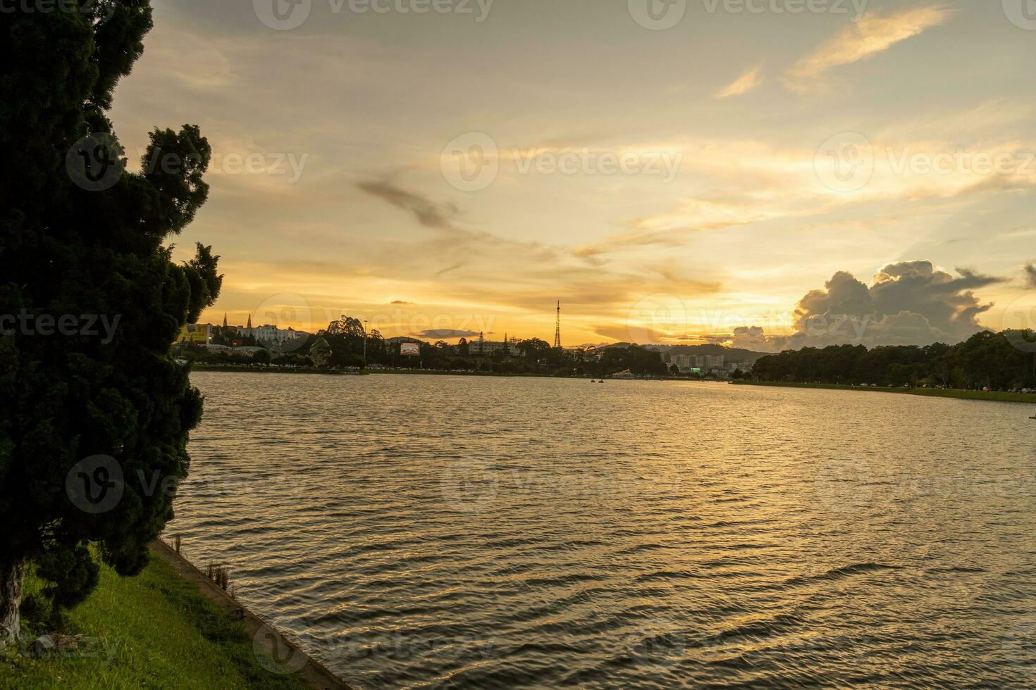Sunset view of a Da Lat City with development buildings, transportation, market. Tourist city with center square of Da Lat city near Xuan Huong lake photo