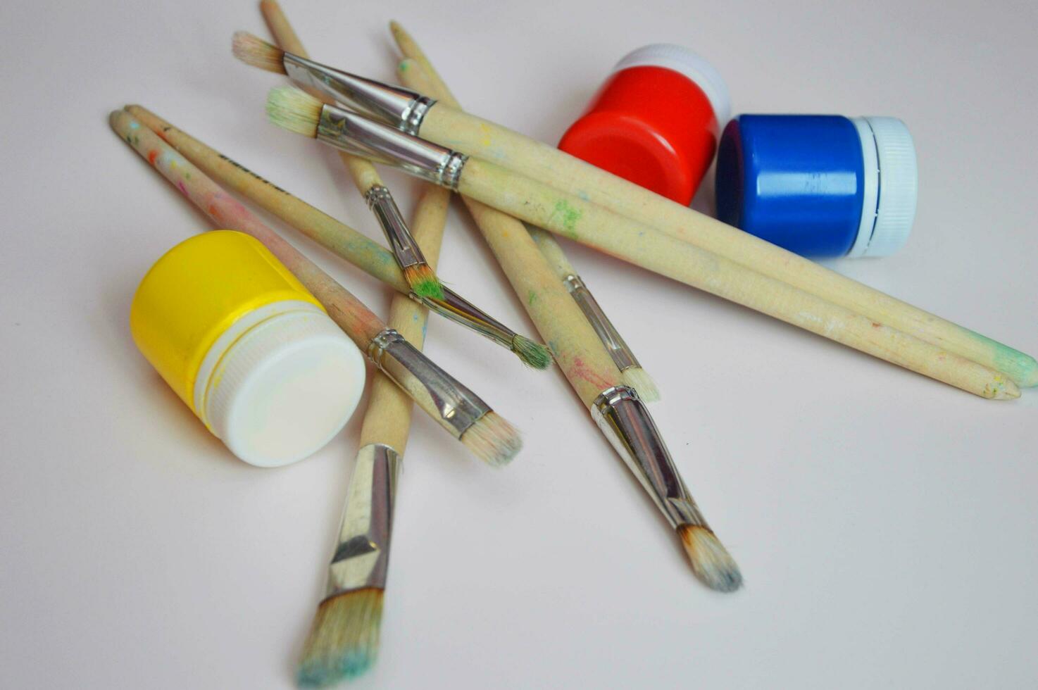 Jars of gouache paints and art brushes. Materials for drawing and creativity, hobbies. photo