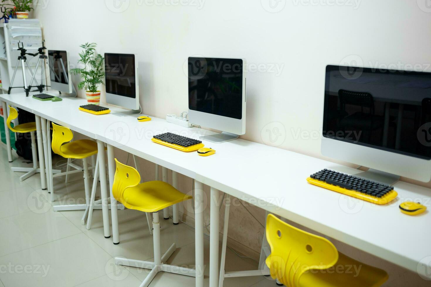un acogedor lugar de trabajo en un trabajo colaborativo espacio con un computadora y un flor en un maceta foto