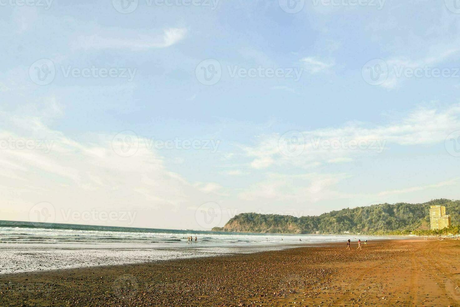 a sandy beach with waves and rocks photo