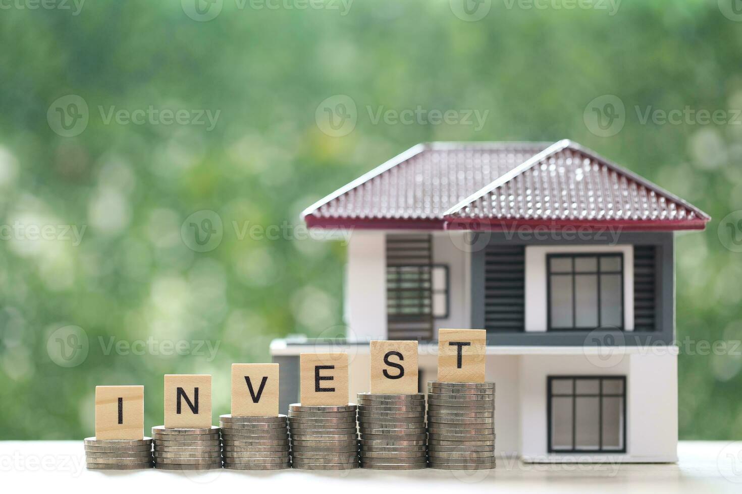 Mortgage,Model house and stack of coins money on natural green background,Business investment and real estate concept photo