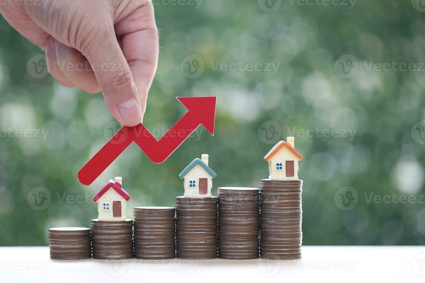 Mortgage,Model house and stack of coins money on natural green background,Business investment and real estate concept photo