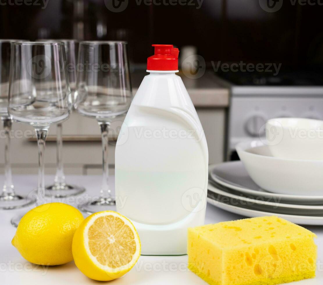 Detergent with lemon and sponge on the table in the kitchen. Cleaning concept. Mockup. Close-up. Selective focus. photo