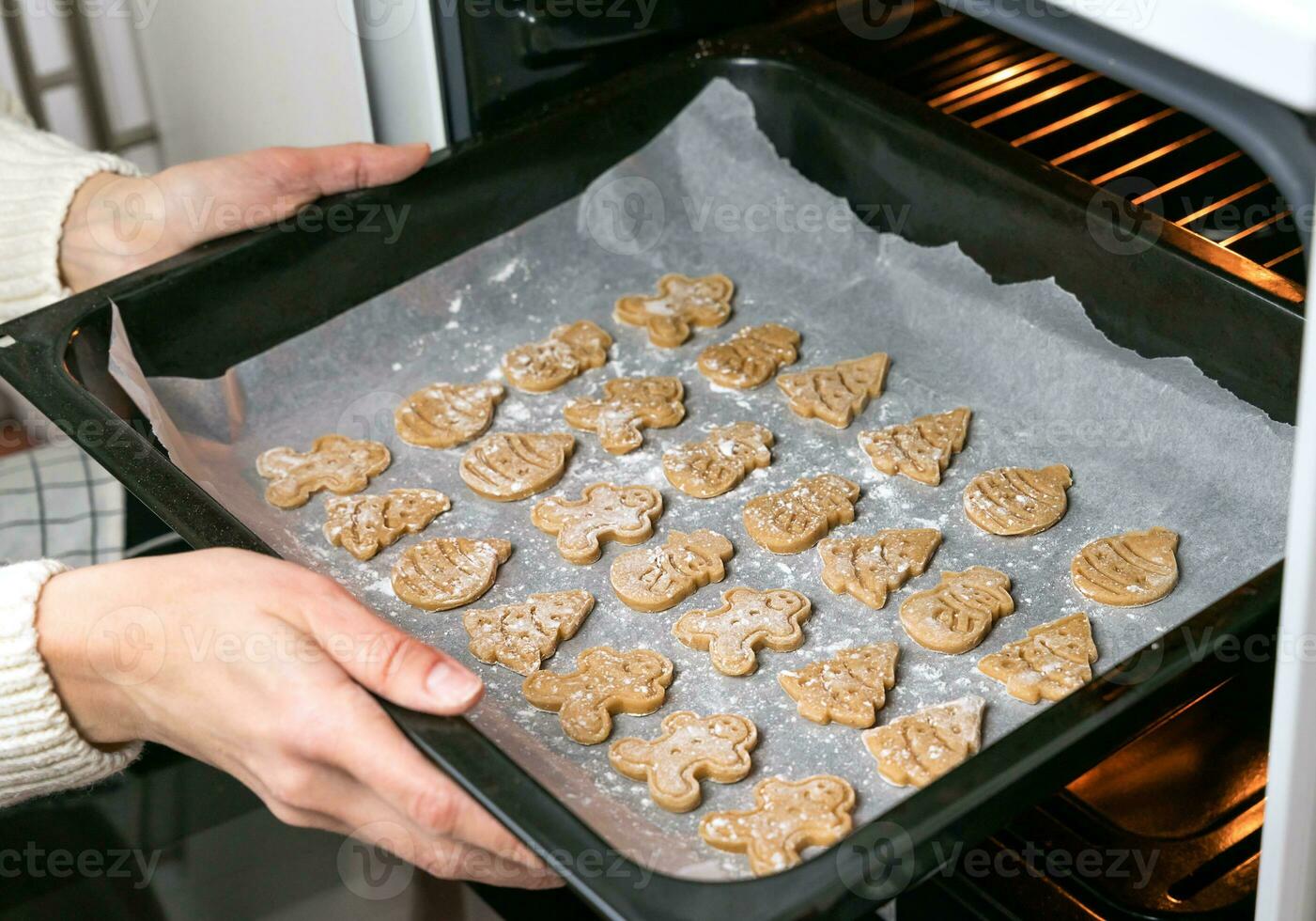 A young woman bakes Christmas cookies at home. Close-up. Selective focus. photo