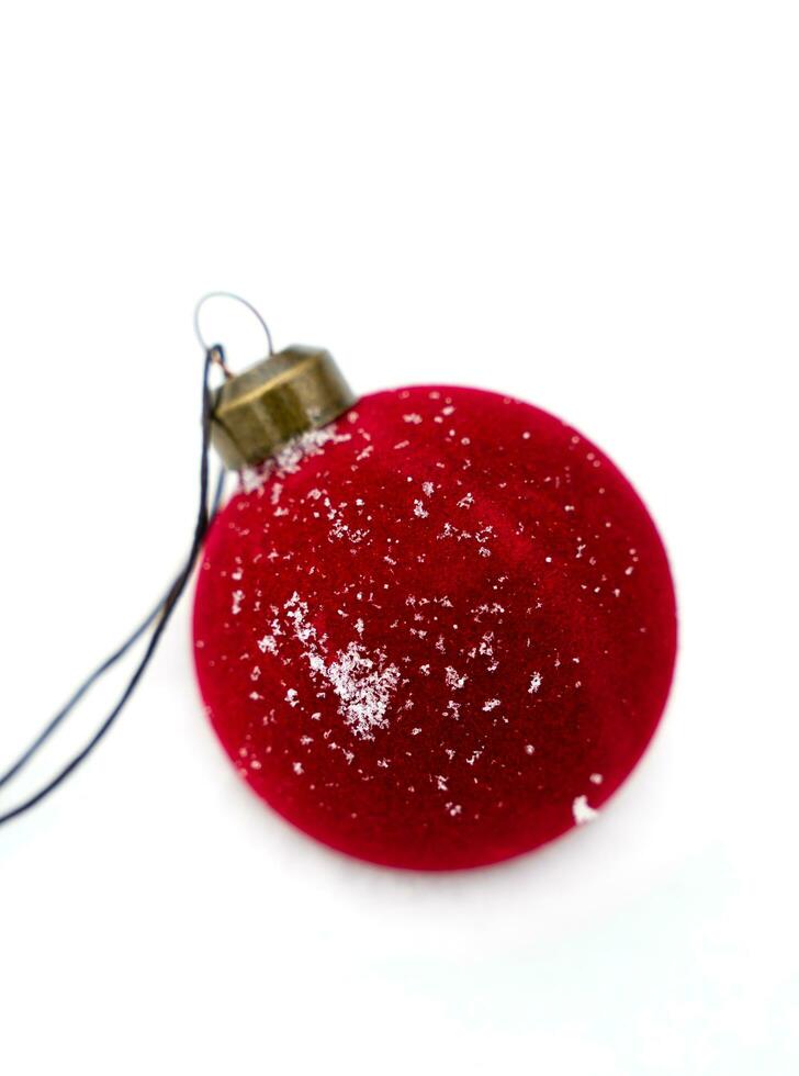 Christmas velvet red ball on the snow. Christmas tree decoration. Close-up. Selective focus. photo