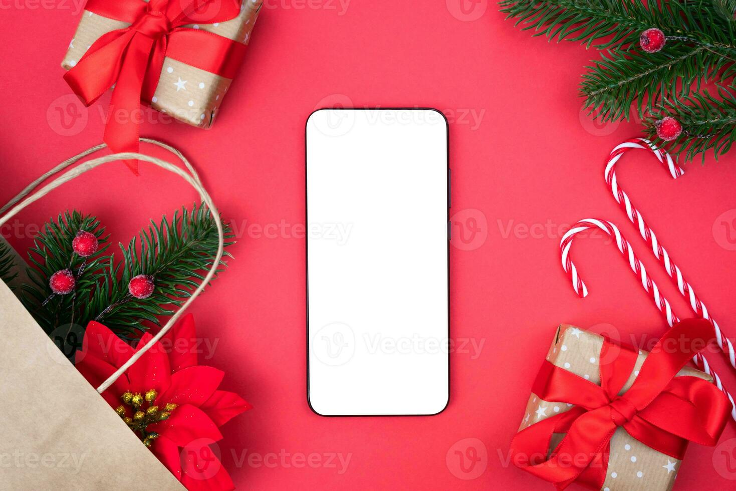 Mobile phone, Christmas gifts and decorations on a red background. Christmas online shopping concept. Copy space. Top view. photo