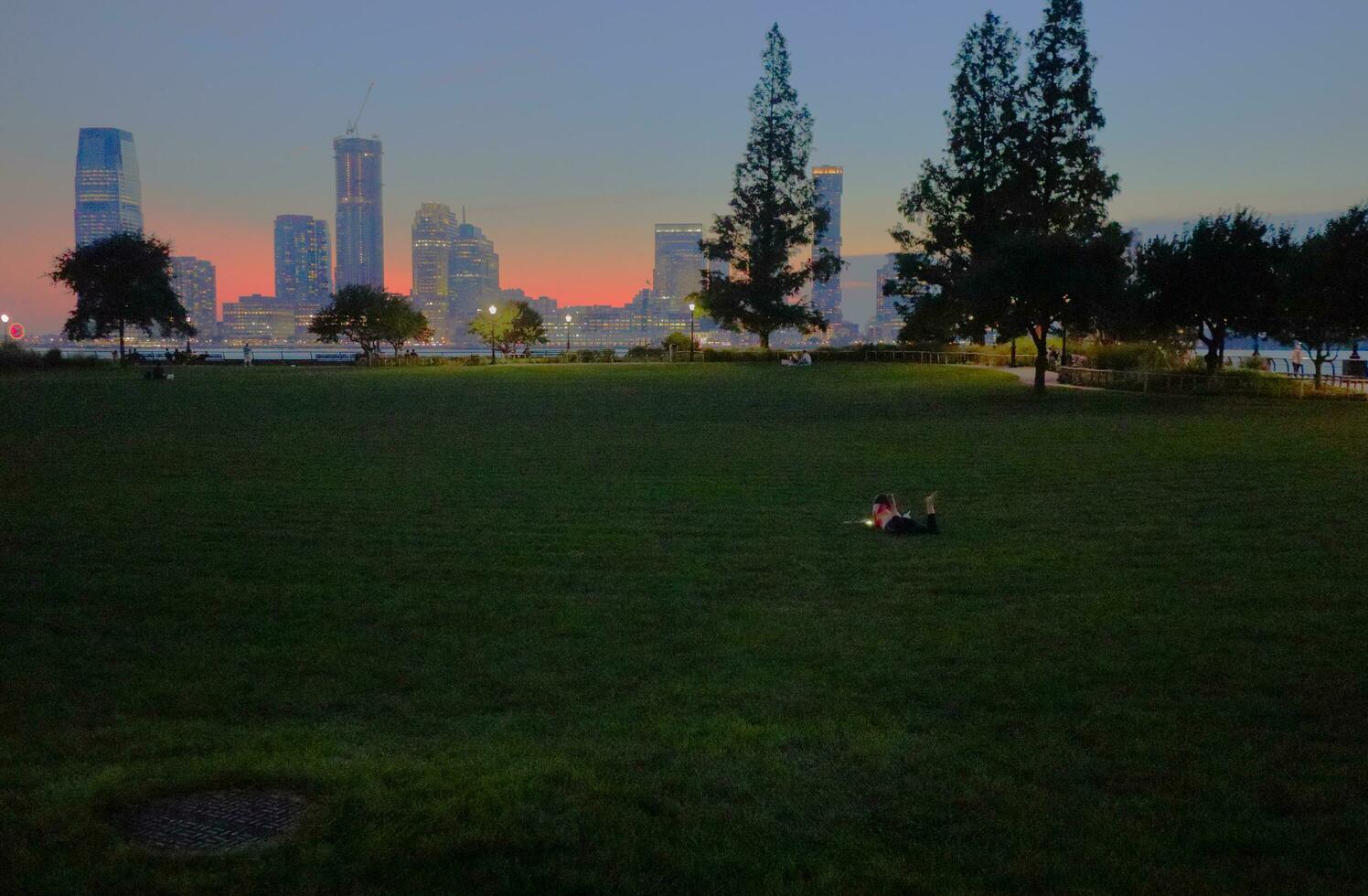 Girl Plays on Phone in Park Evening photo