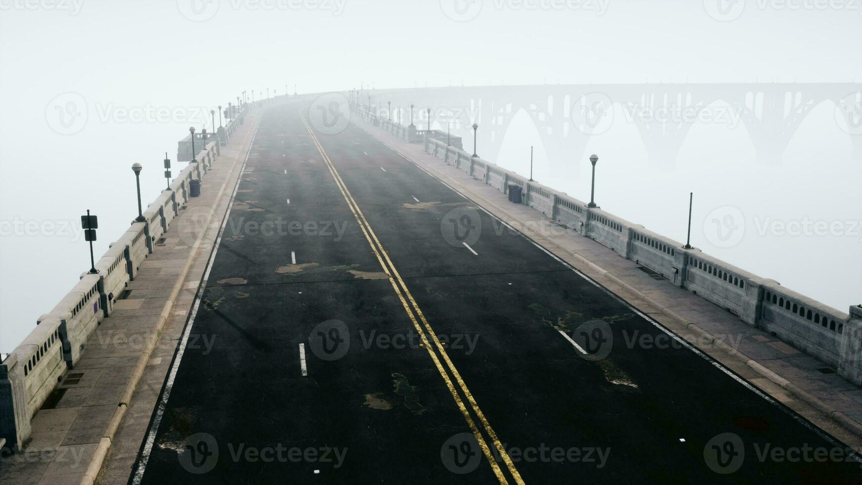 An empty illuminated asphalt road in a thick fog photo