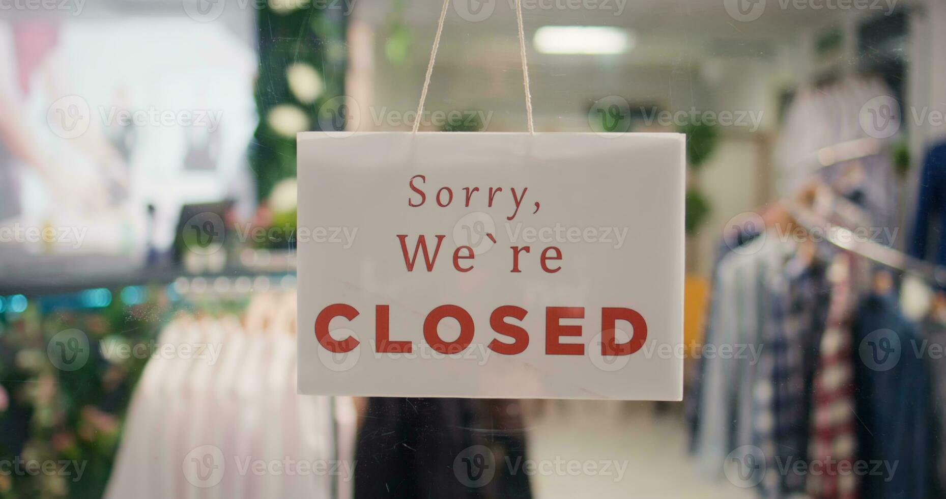 Trendy clothing store being closed at night after finished working hours. Extreme close up shot on sorry we are closed message sign on fashion boutique door in mall at shift end photo