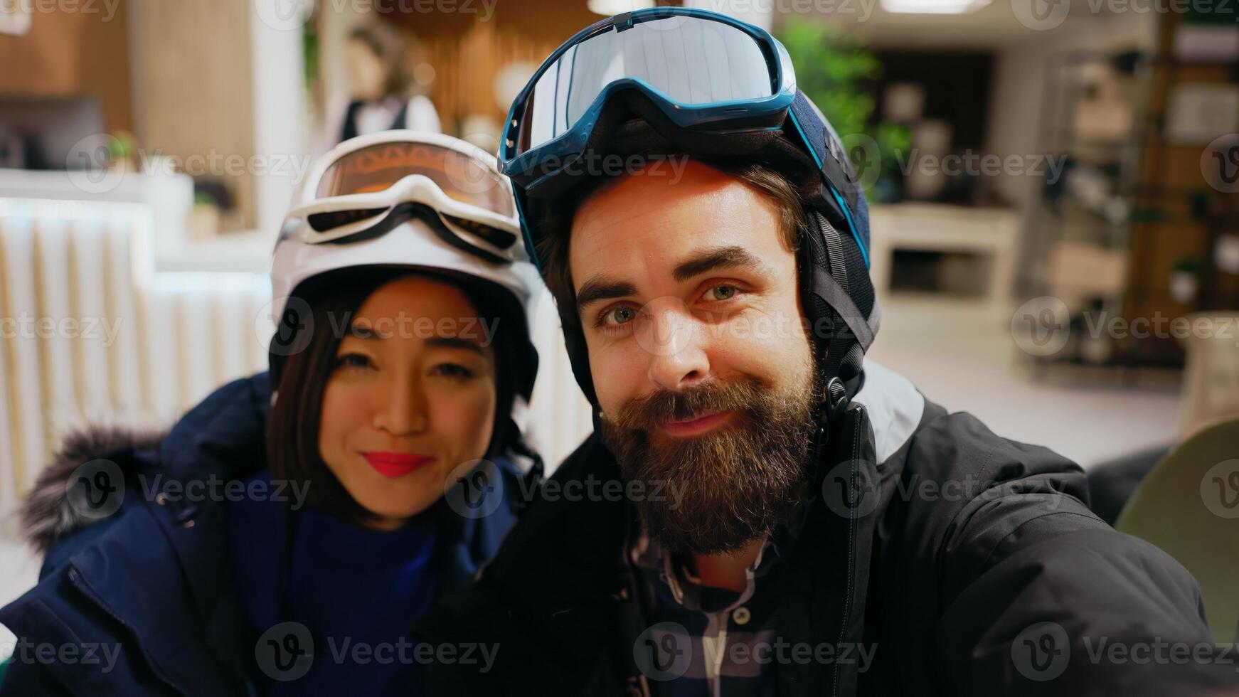 POV of couple answering videocall chat on smartphone, discussing with friends about winter adventure at alpine luxury hotel. Man and woman talking on online conference, mountain resort. Handheld shot. photo