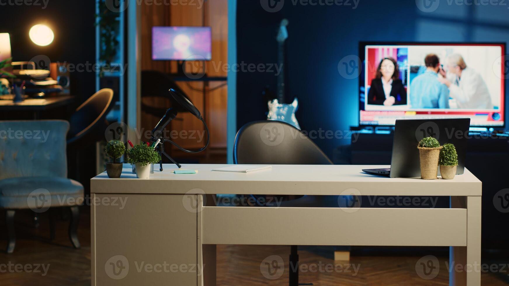 Panning shot of work desk with professional microphone and mini house plants in dimly lit empty home studio interior. Broadcast recording tech in living room illuminated by RGB lights photo