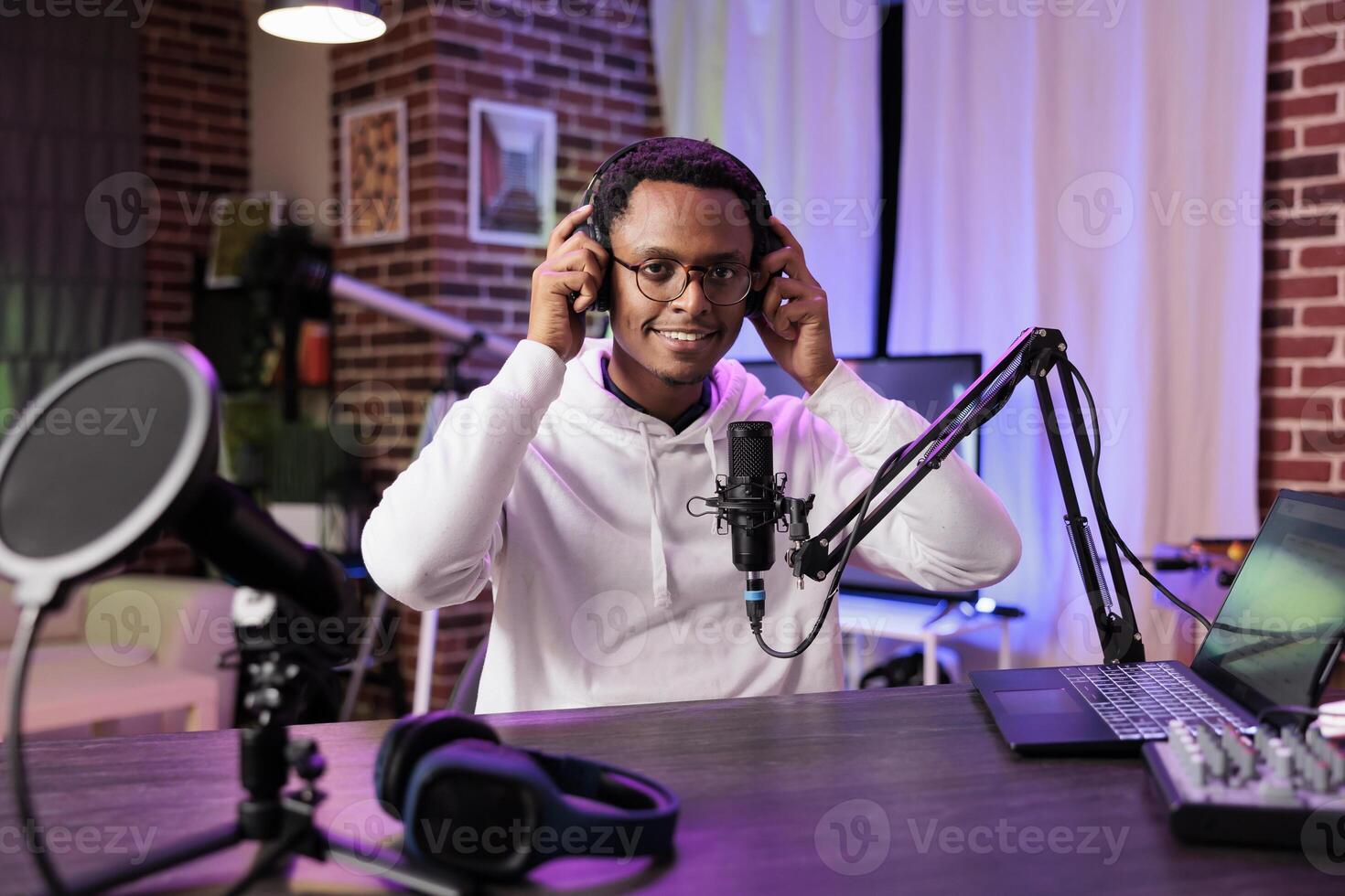 Popular vlogger recording internet show with professional camera and sound equipment in studio. Portrait of content creator talking to watchers and filming for online streaming platform photo