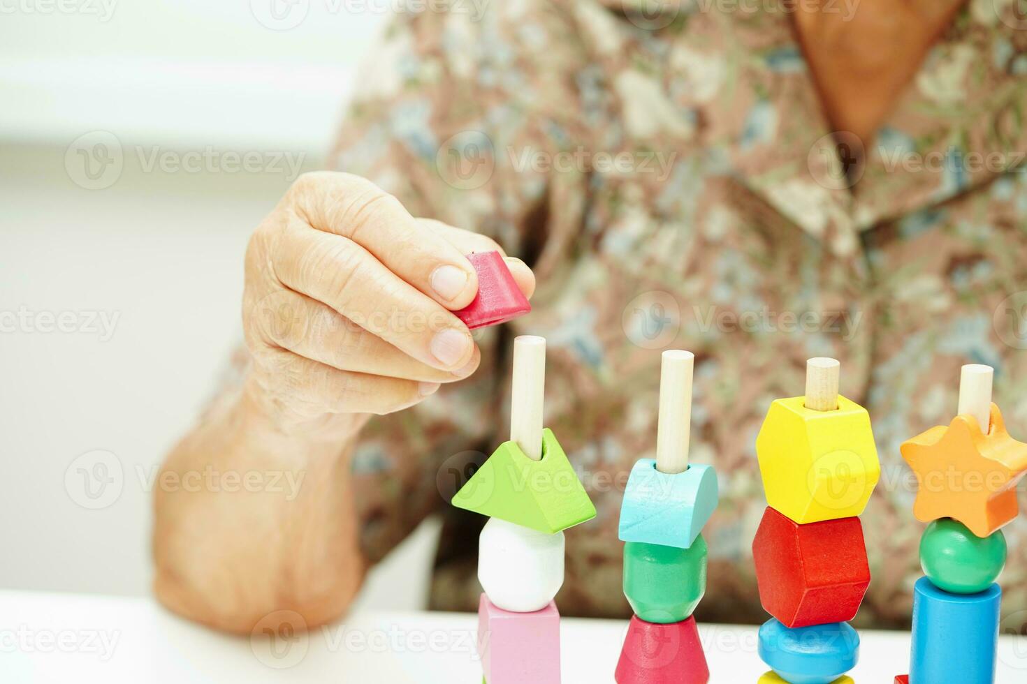 Asian elderly woman playing puzzles game for treatment dementia prevention and Alzheimer disease. photo