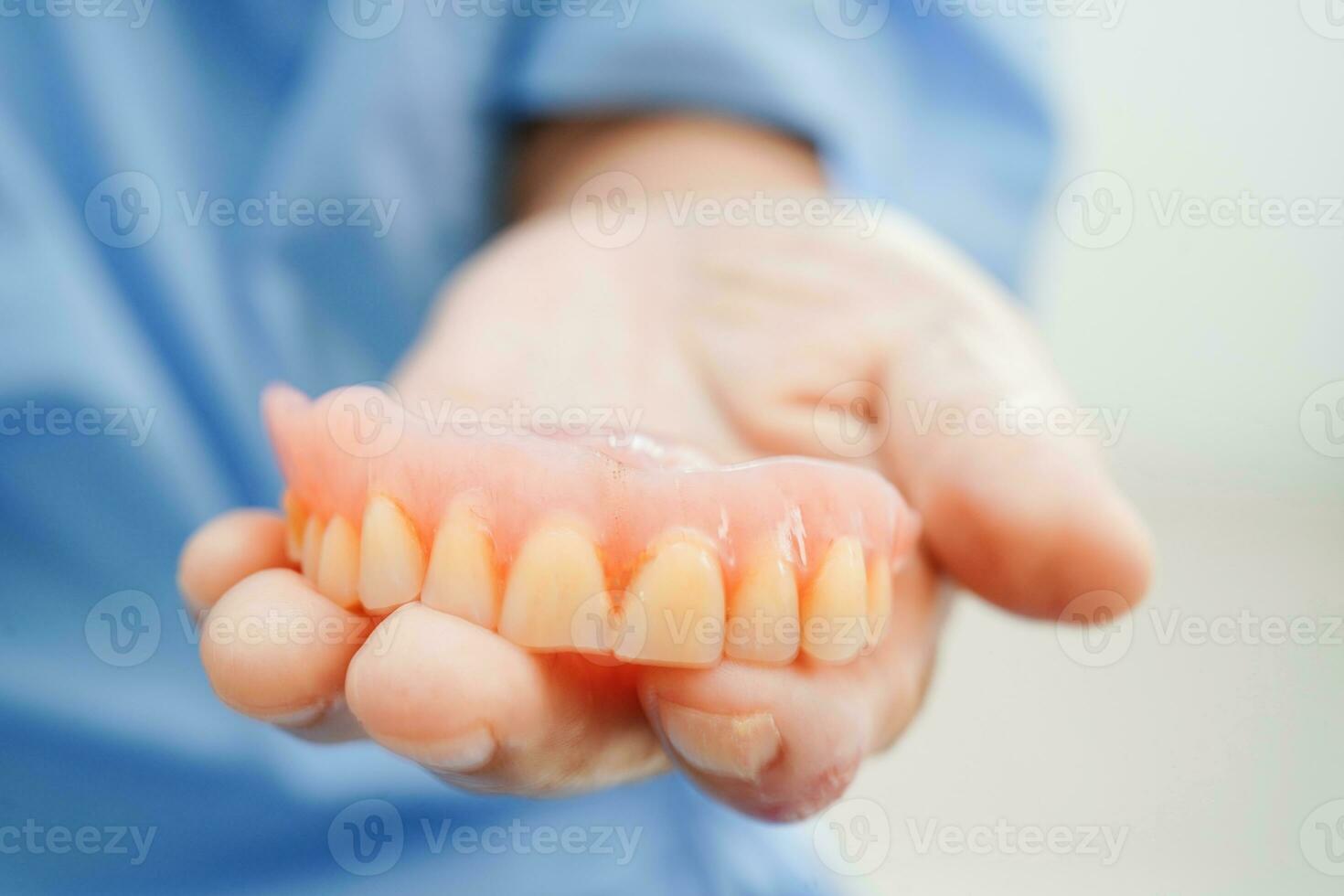 Doctor holding teeth denture in hand for dentist studying about dentistry. photo
