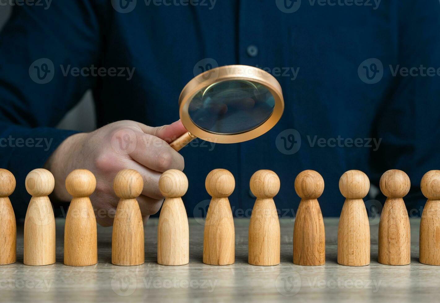 A man studies people through a magnifying glass. Sociology and marketing. Finding people and workers on the job. Uncover patterns, motivations, and influences that guide community behavior photo