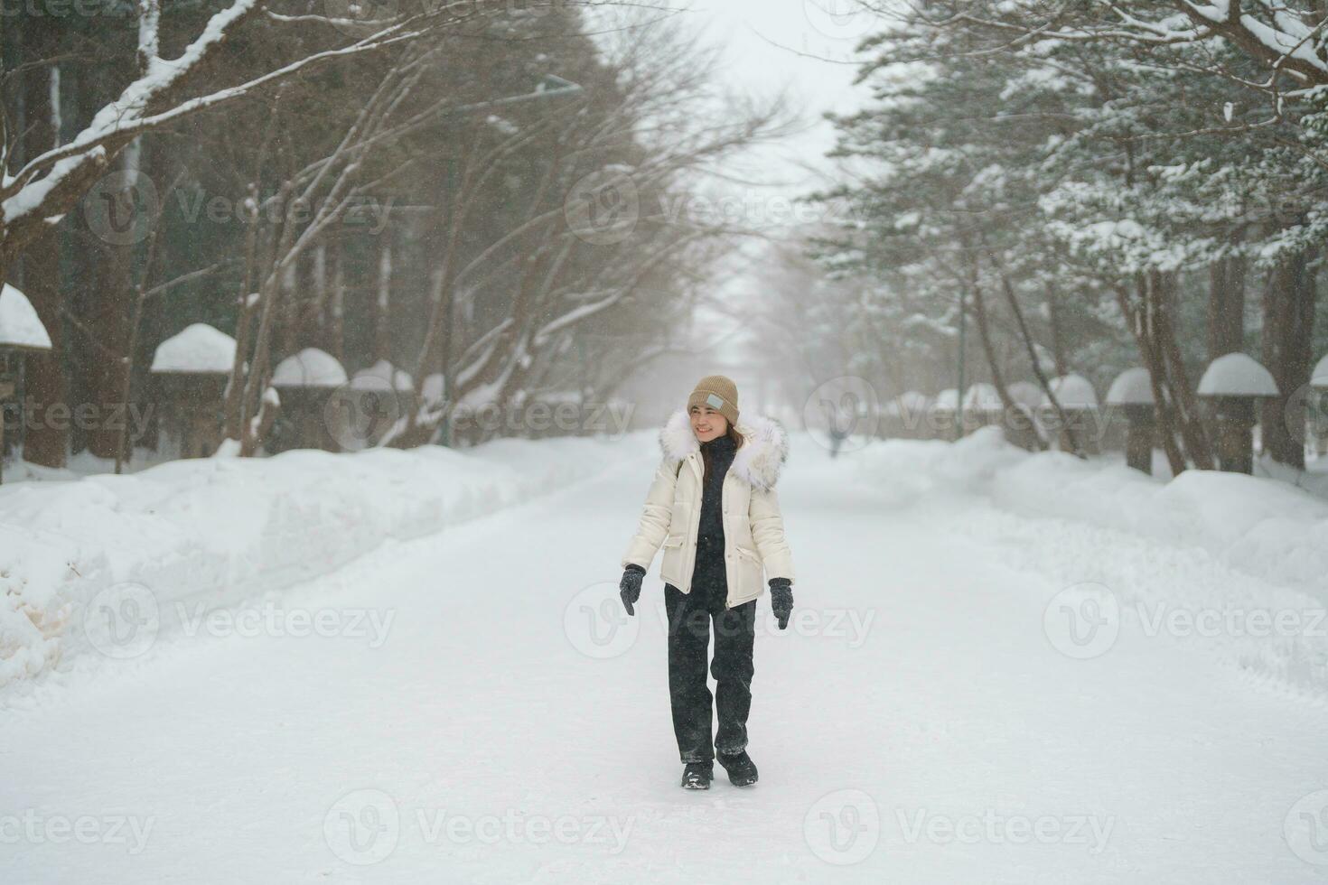 happy Traveler with Sweater and backpack walking on snow covered forest in frosty weather. Winter Travel, Adventure, Exploring and Vacation concept photo