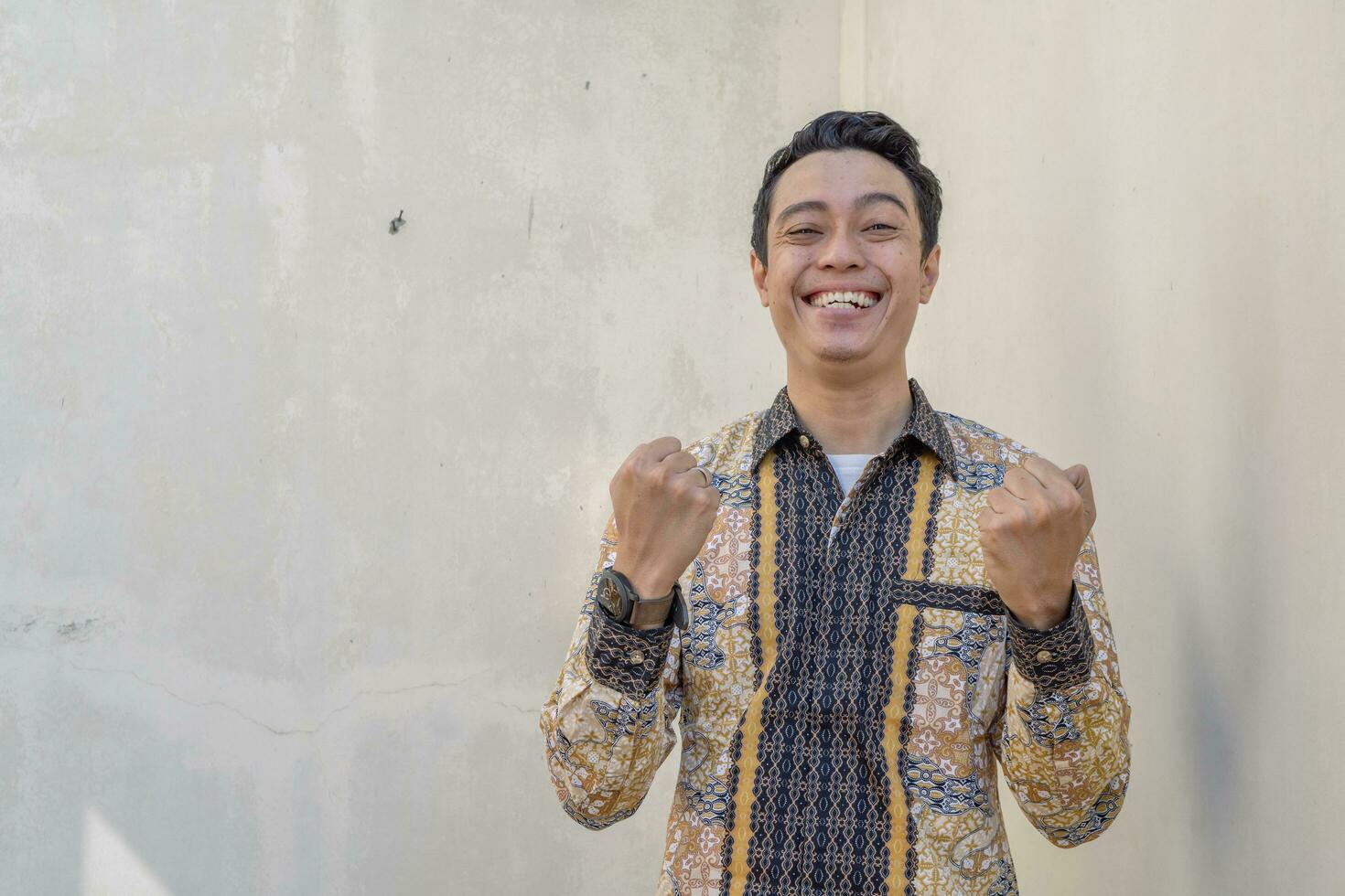 joven indonesio vestir batik tradicional cultura Indonesia con salud gesto foto