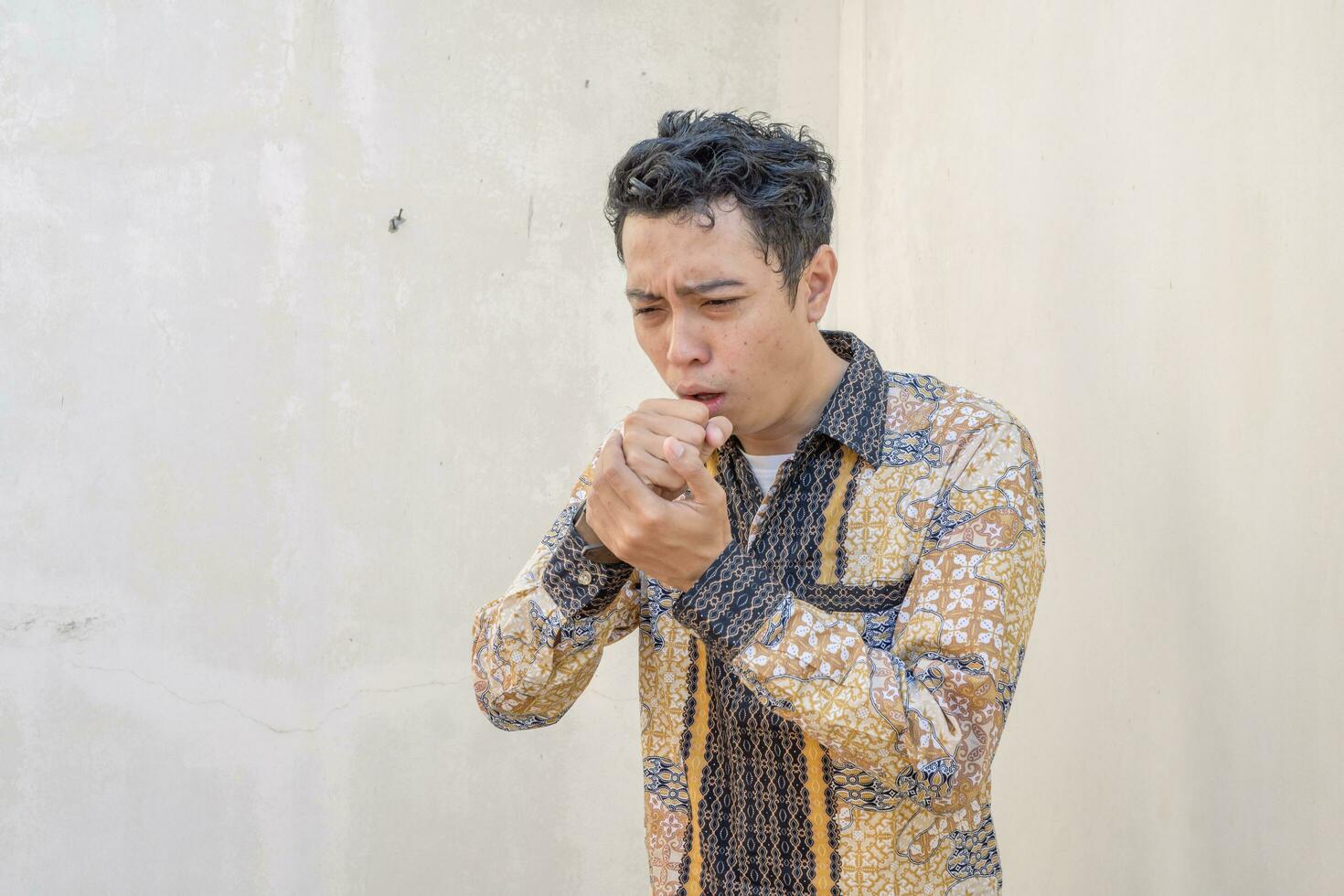 joven indonesio vestir batik tradicional cultura Indonesia con tos gesto. foto