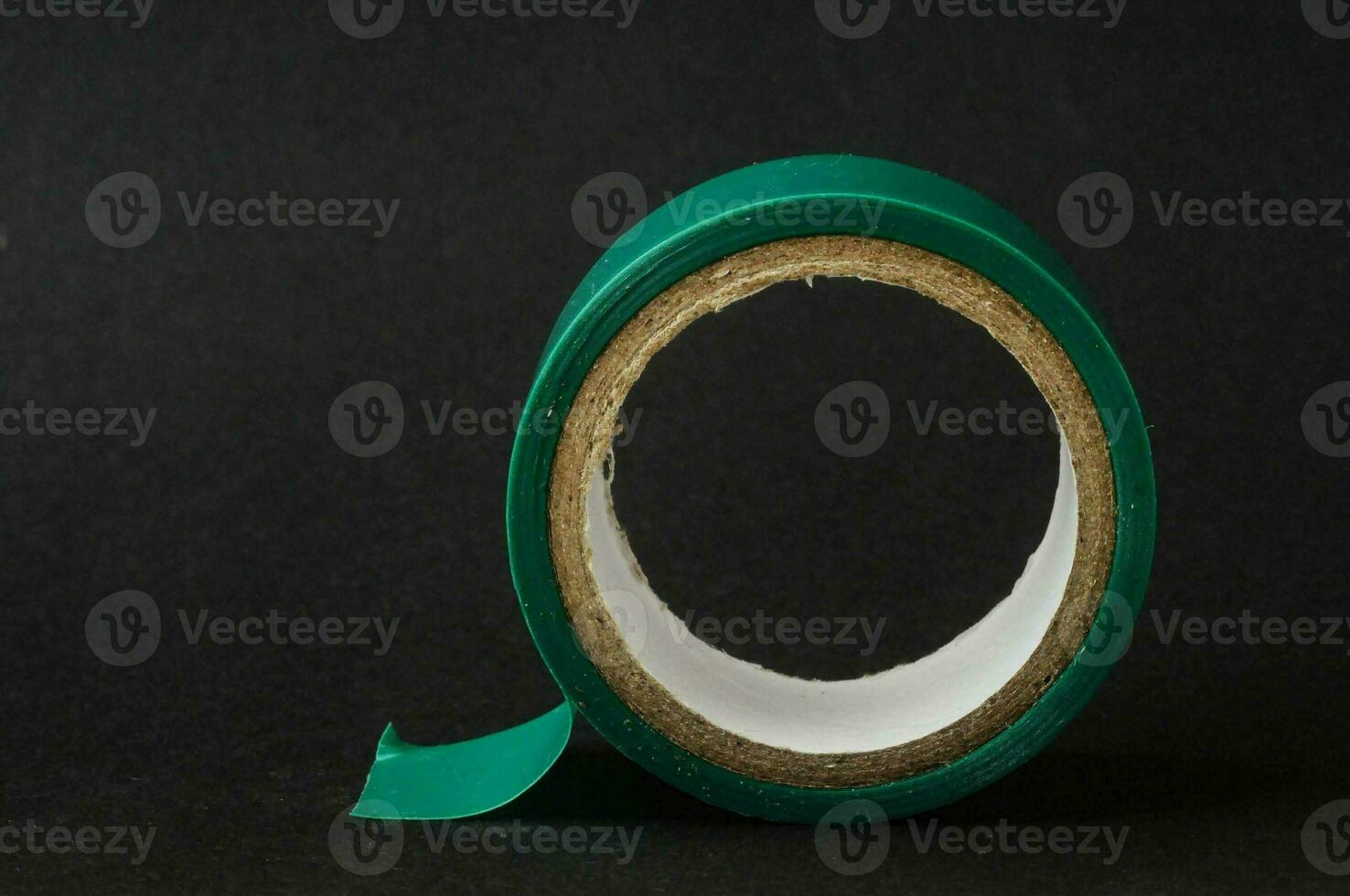 a roll of green tape on a black surface photo