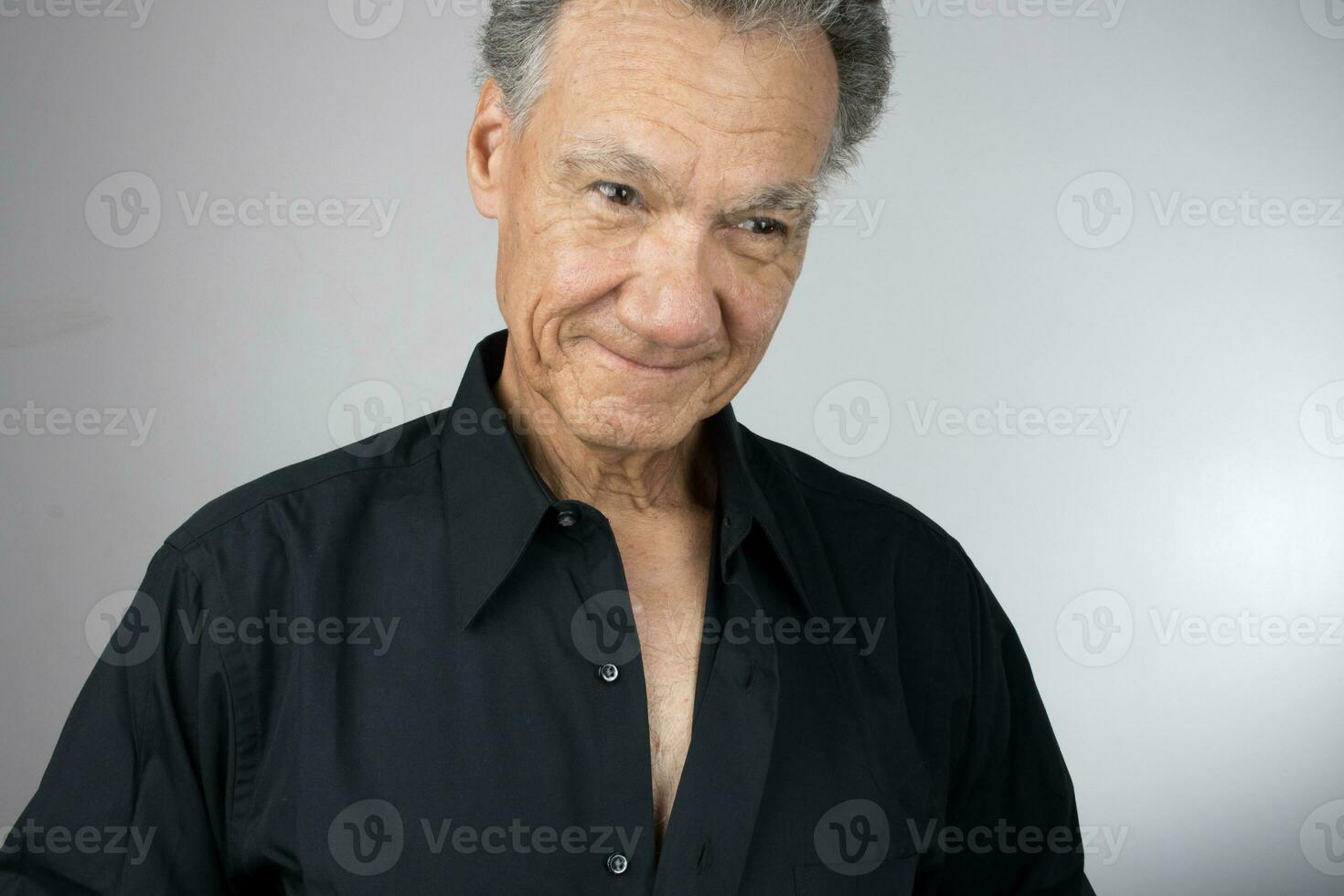 Mature Senior Man buttoning up his shirt while getting dress for work photo