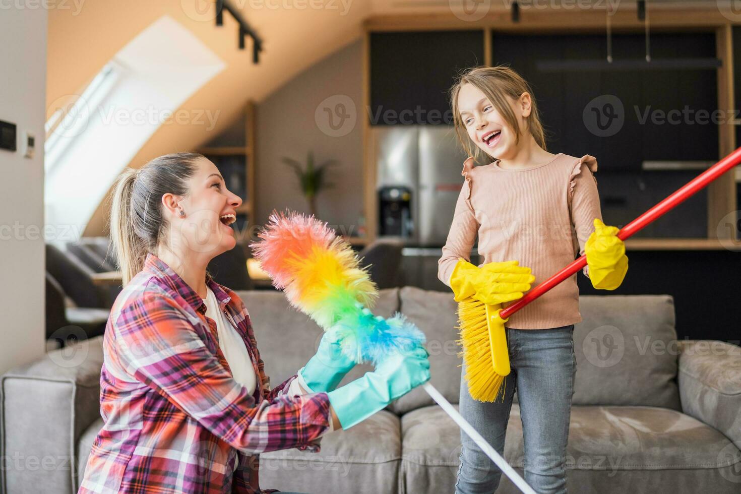 contento madre y hija teniendo divertido mientras limpieza casa juntos foto