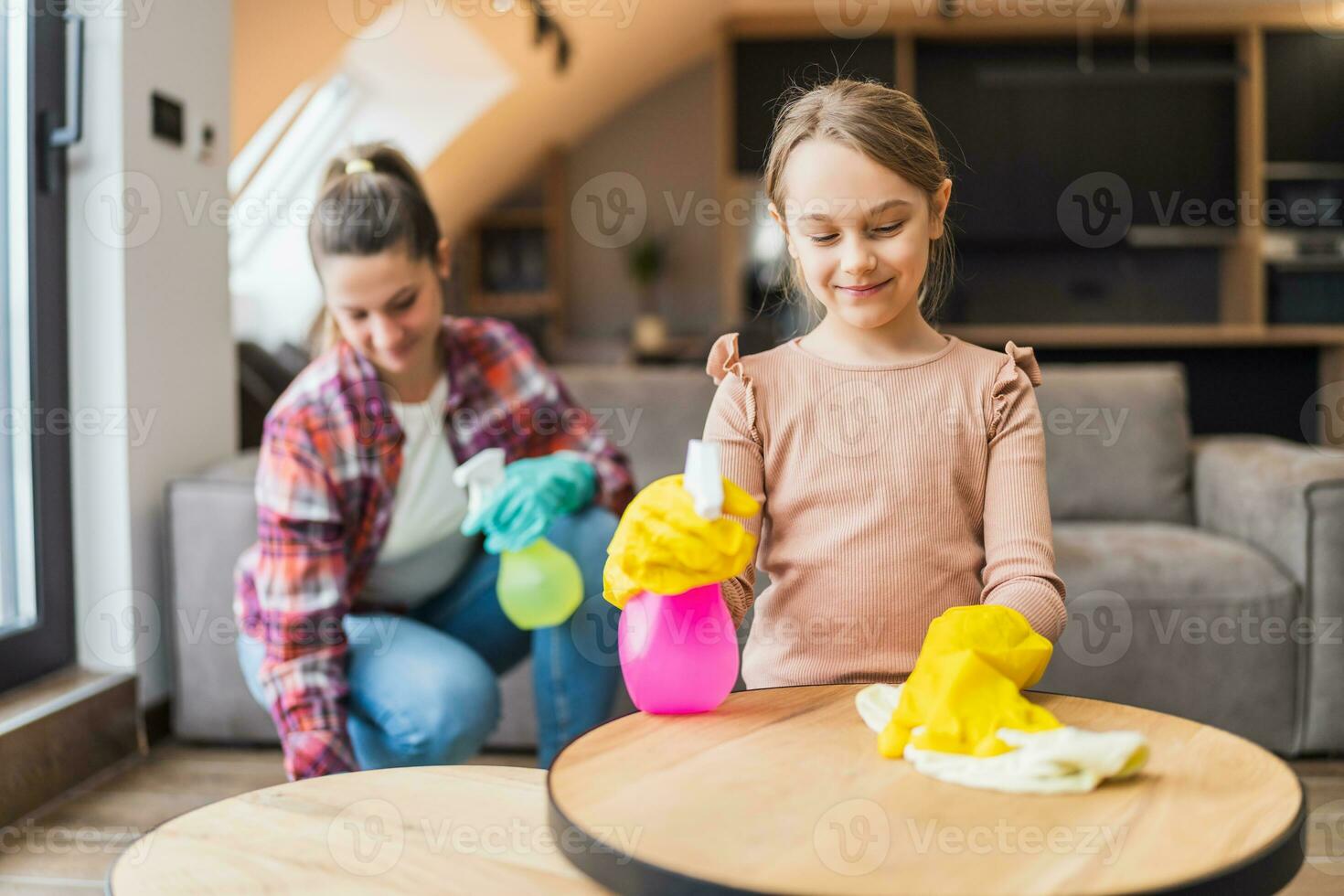 Happy daughter and mother cleaning house together. photo