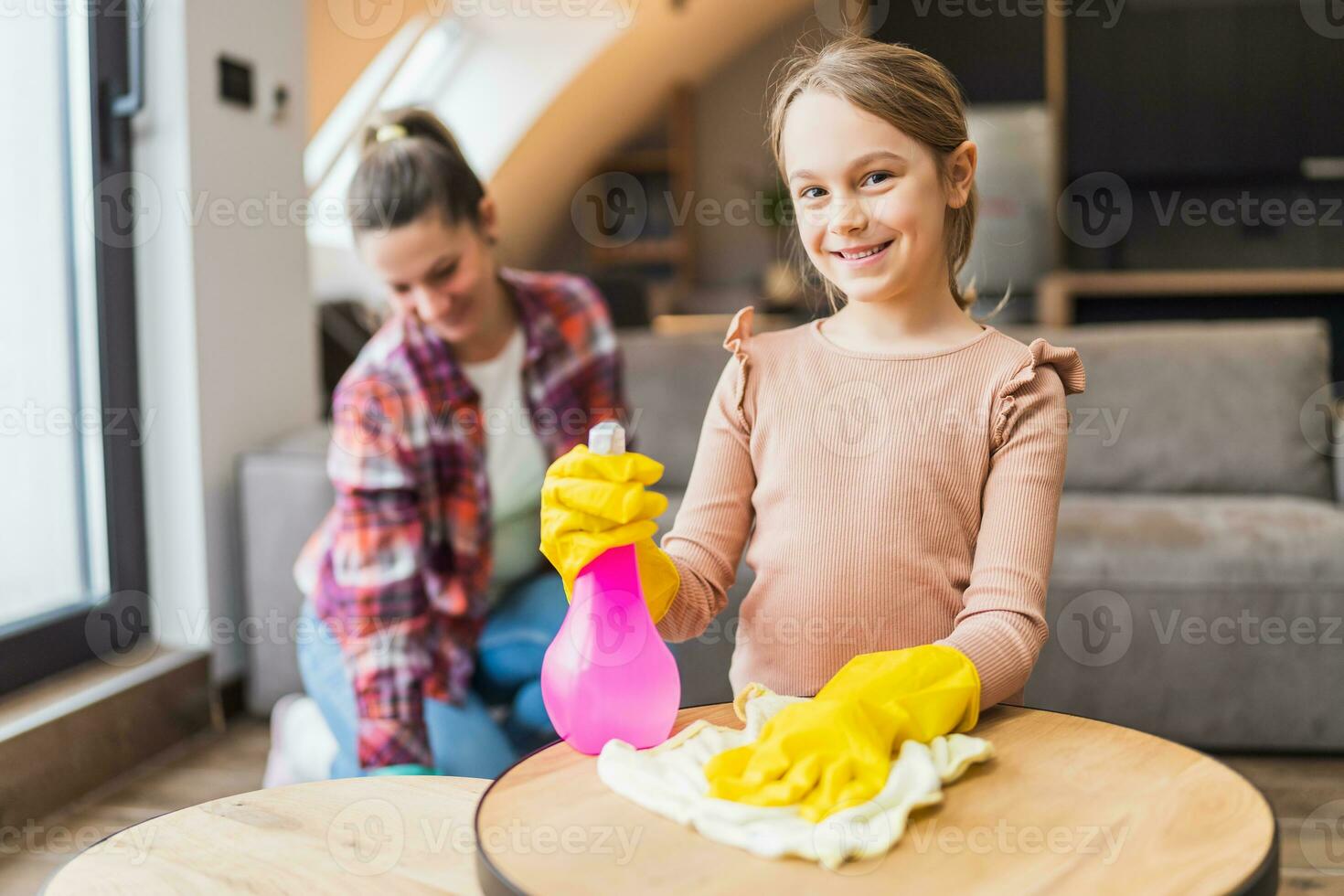 Happy daughter and mother cleaning house together. photo