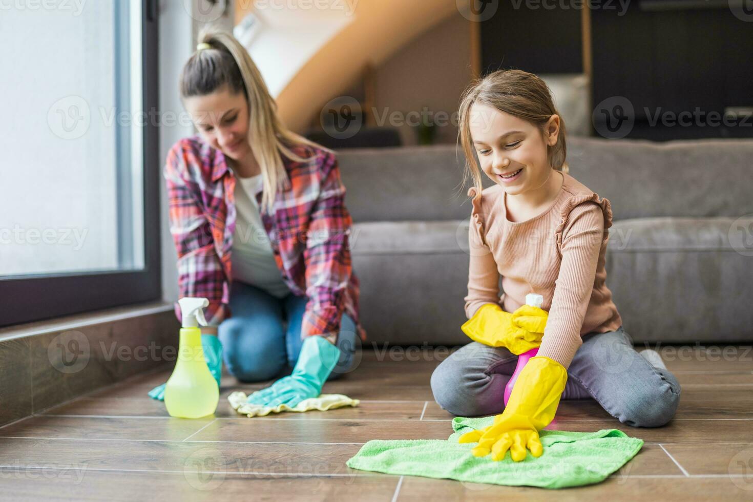 Happy daughter and mother cleaning house together. photo