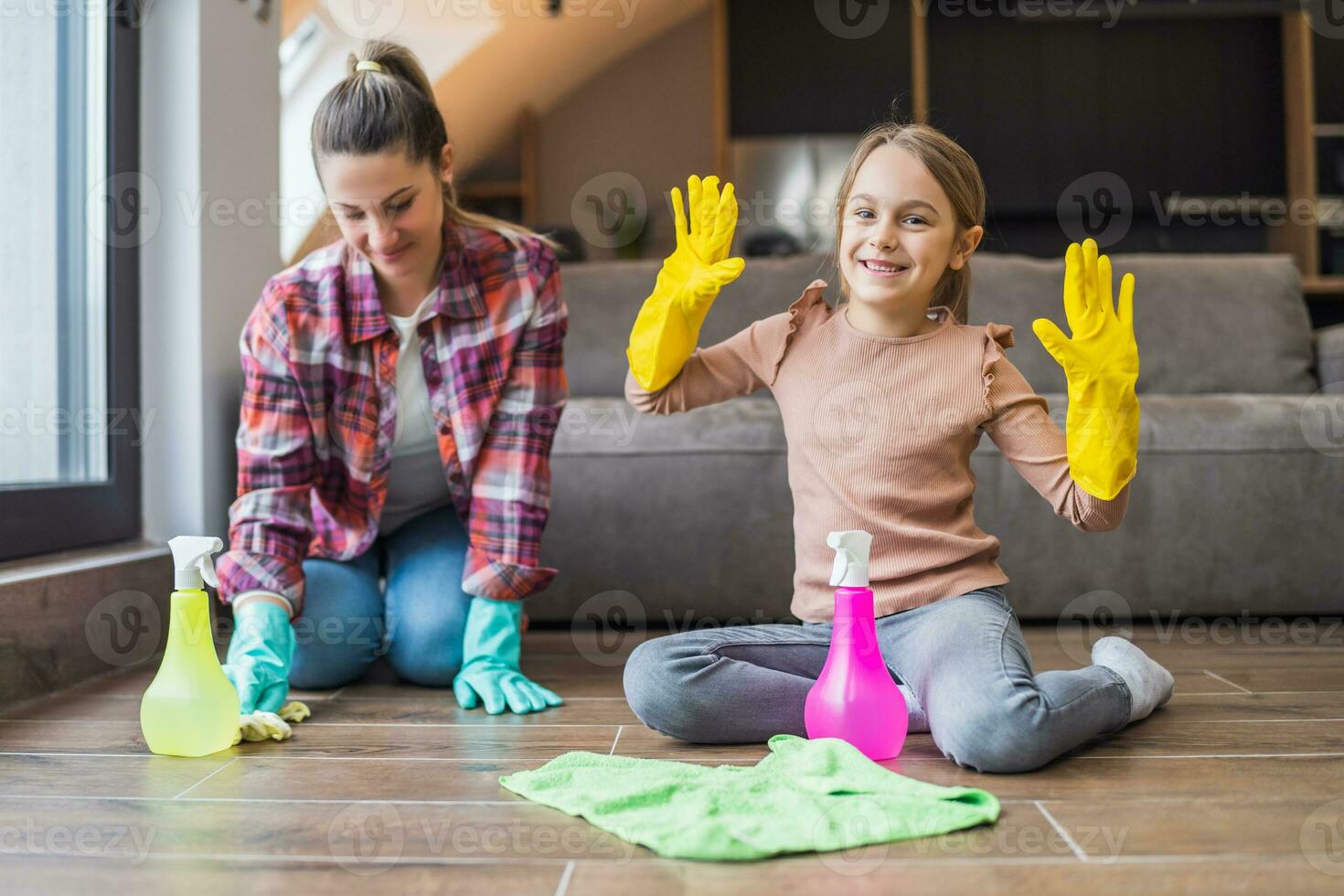Happy daughter and mother cleaning house together photo