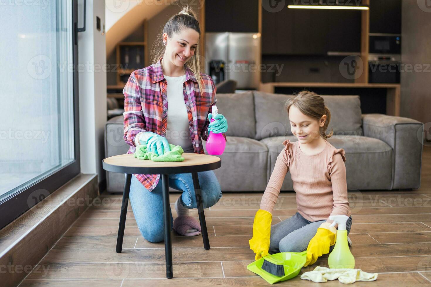 Happy mother and daughter cleaning house together photo