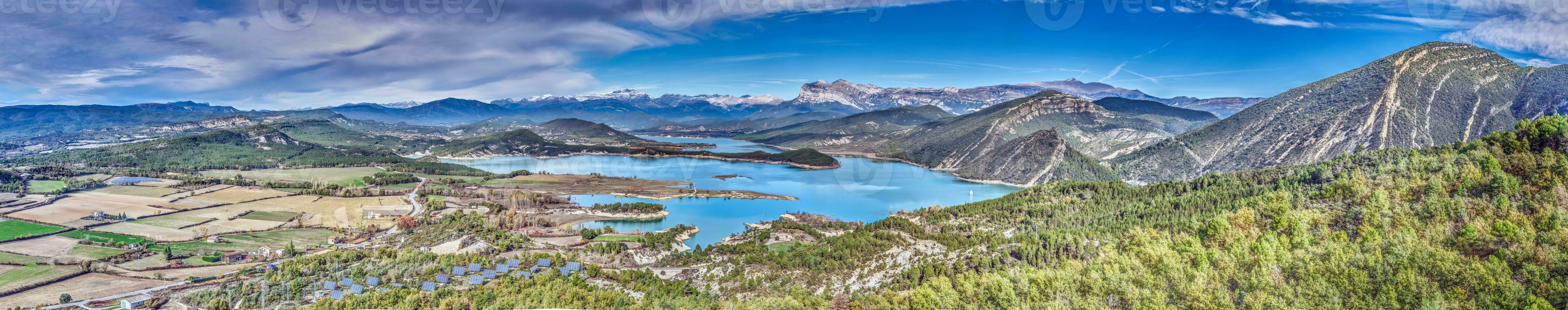 zumbido panorama terminado el mediano reservorio en el Español Pirineos con cubierto de nieve montañas en el antecedentes foto