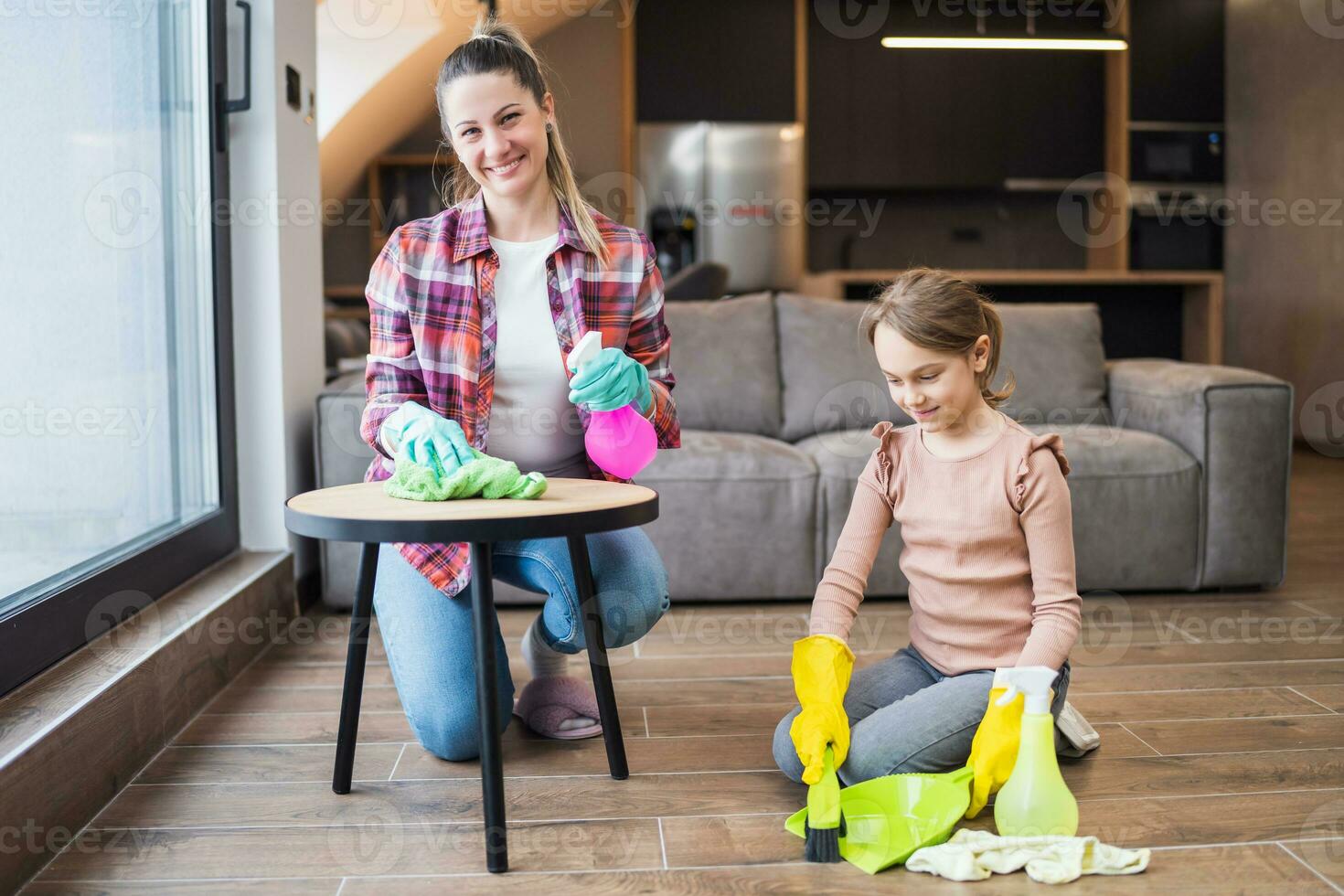 Happy mother and daughter cleaning house together photo