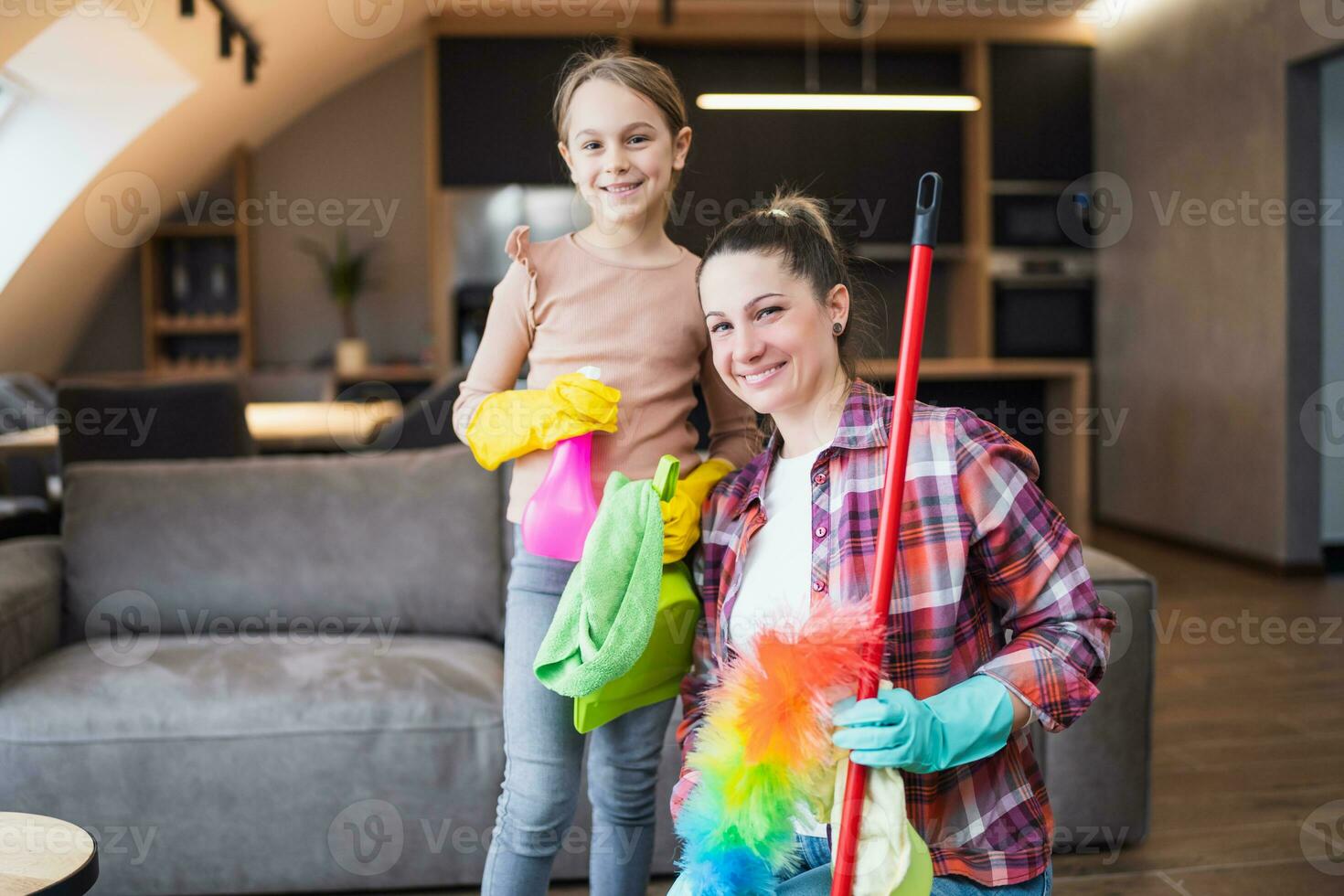 Happy mother and daughter cleaning house together photo