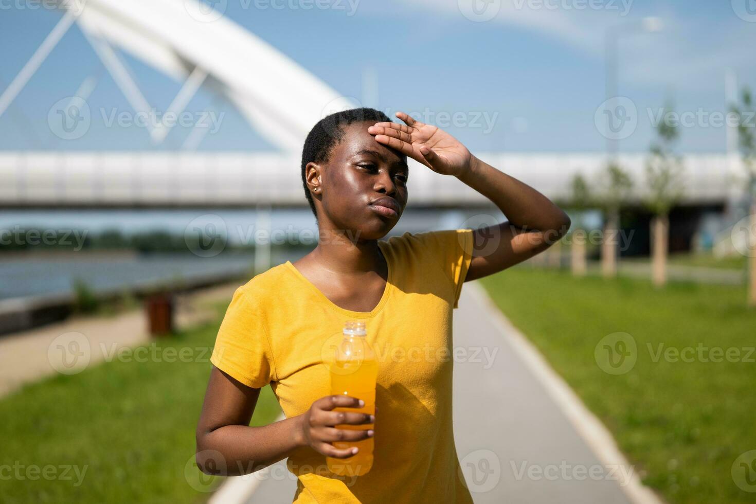 Exhausted woman drinking energy drink after exercise photo