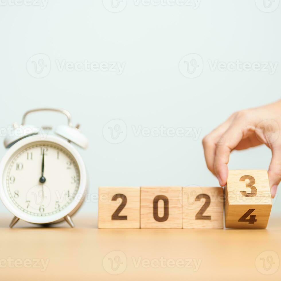 Happy New Year with vintage alarm clock and flipping 2023 change to 2024 block. Christmas, New Start, Resolution, countdown, Goals, Plan, Action and Motivation Concept photo